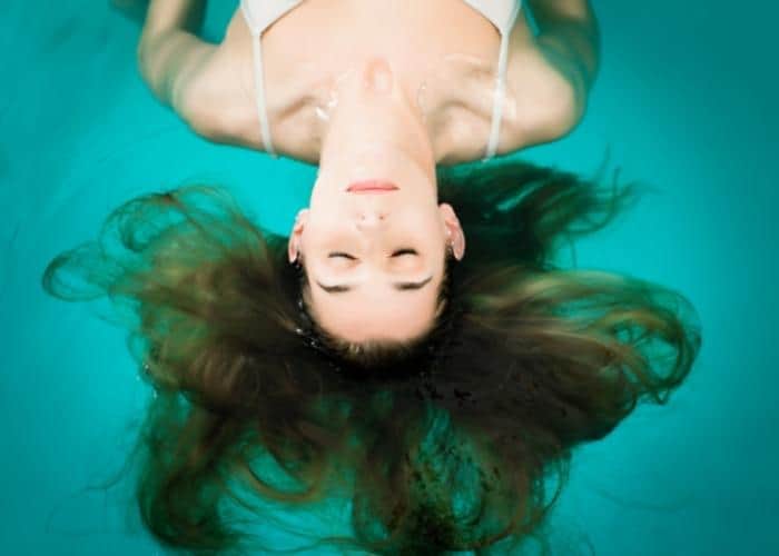Woman floating in water representing Flotation Therapy